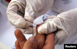 Seorang perawat mengambil darah untuk uji HIV gratis selama kampanye pencegahan HIV yang menandai Hari AIDS Sedunia di Lima, Peru