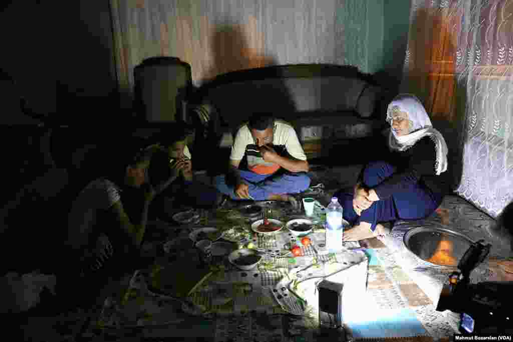 The government has cut power and water to Sur, in Diyarbakir, Turkey, as efforts are made to rebuild it. A family eats by the light of a lantern in their home.