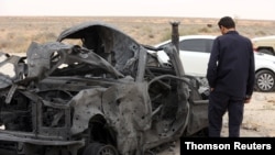 A fighter loyal to Libya's internationally recognised government checks a damaged vehicle after taking control of al-Watiya airbase, southwest of Tripoli, Libya, May 18, 2020.