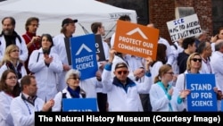 FILE - Researchers and supporters hold signs at a rally during the American Geophysical Union meeting in San Francisco, California, Dec., 2016.