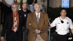 Mantan pelatih sepakbola Amerika, Jerry Sandusky (tengah) dikawal pihak berwajib meninggalkan pengadilan setelah divonis bersalah terkait pelecehan seks di Bellefonte, Philadelphia (22/6).