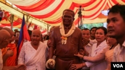 Kem Ley's mother, left, and family members stand alongside Kem Ley's statue in Takeo province, Sunday October 15, 2016. (Leng Len/VOA Khmer)