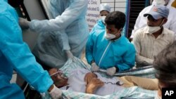 Health workers carry a patient after a fire in Vijay Vallabh COVID-19 hospital at Virar, near Mumbai, India, April 23, 2021. 