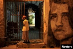 FILE - An elderly woman stands outside her house in Havana, Cuba, Dec. 31, 2015.
