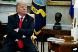 FILE - President Donald Trump listens during a meeting with North Korean defectors, in the Oval Office of the White House, Feb. 2, 2018.