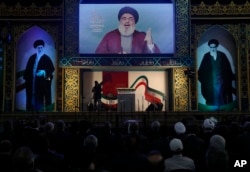 FILE - Hezbollah leader Hassan Nasrallah delivers a broadcast speech during a rally to commemorate the 40th anniversary of Iran's Islamic Revolution, in southern Beirut, Lebanon, Feb. 6, 2019.