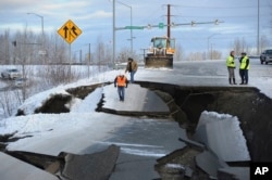 Workers inspect an off-ramp that collapsed during a morning earthquake, Nov. 30, 2018, in Anchorage, Alaska.