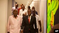 FILE - Presidential candidate Jovenel Moise, right, from the PHTK party, leaves after a press conference in Port-au-Prince, Haiti, Monday, Jan. 4, 2016.