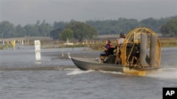Des spécialistes du génie militaire américain travaillant à l'ouverture du déversoir de Bonnet Carret, à Norco, en Louisiane. Cet ouvrage achemine les eaux d'inondation vers le Lac Pontchartrain