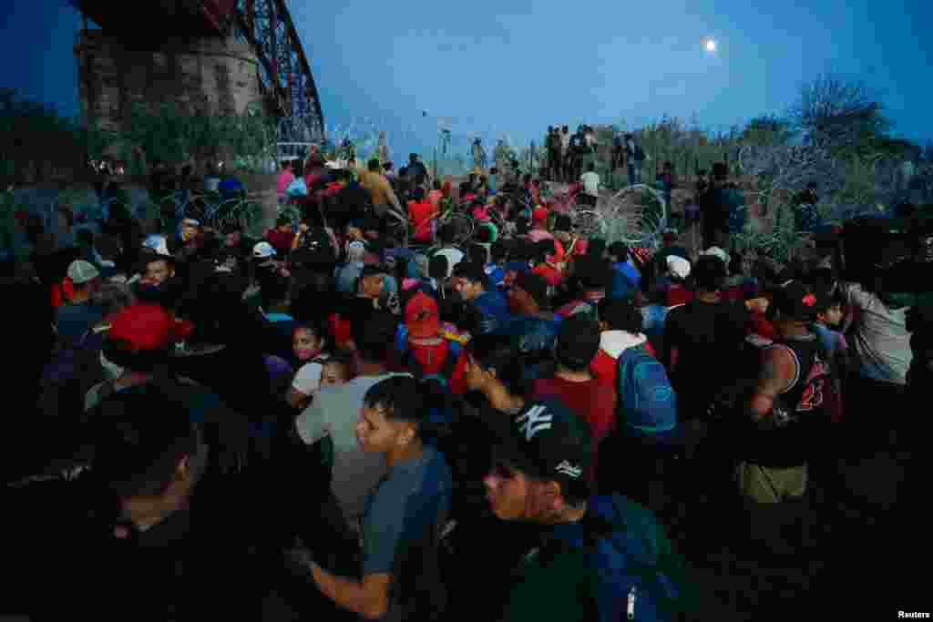 Asylum seekers wait on the banks of the Rio Bravo river after crossing during their journey through Mexico to Eagle Pass, Texas, in Piedras Negras, Mexico, Sept. 26, 2023.