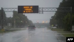 Cars drive on a wet road as rain from Hurricane Florence falls in Wilmington, North Carolina, Sept. 13, 2018. The huge storm weakened to a Category 1 hurricane overnight, but forecasters warned that it still packed dangerous winds and torrential rains.