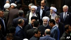 ប្រធានាធិបតី​អ៊ីរ៉ង់ Hasan Rouhani (កណ្តាល)​ ចាកចេញ​ពី​សភា​បន្ទាប់​ពិធី​ស្បថស្បែបាន​បញ្ចប់នៅ​ក្នុង​ការិយា​ល័យ​ក្នុង​ទីក្រុង​ Tehran ប្រទេស​អ៊ីរ៉ងកាលពី​ថ្ងៃទី​០៥ ខែ​សីហា ២០១៧។