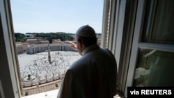 Pope Francis waves to people at St. Peter's Square after the Regina Coeli prayer, which was held without public participation due to the COVID-19 outbreak, at the Vatican, May 24, 2020. Vatican Media/Handout via REUTERS ATTENTION…
