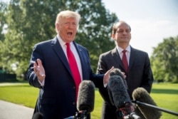 FILE - President Donald Trump, accompanied by then-Labor Secretary Alex Acosta, speaks to reporters on the South Lawn of the White House in Washington, July 12, 2019.