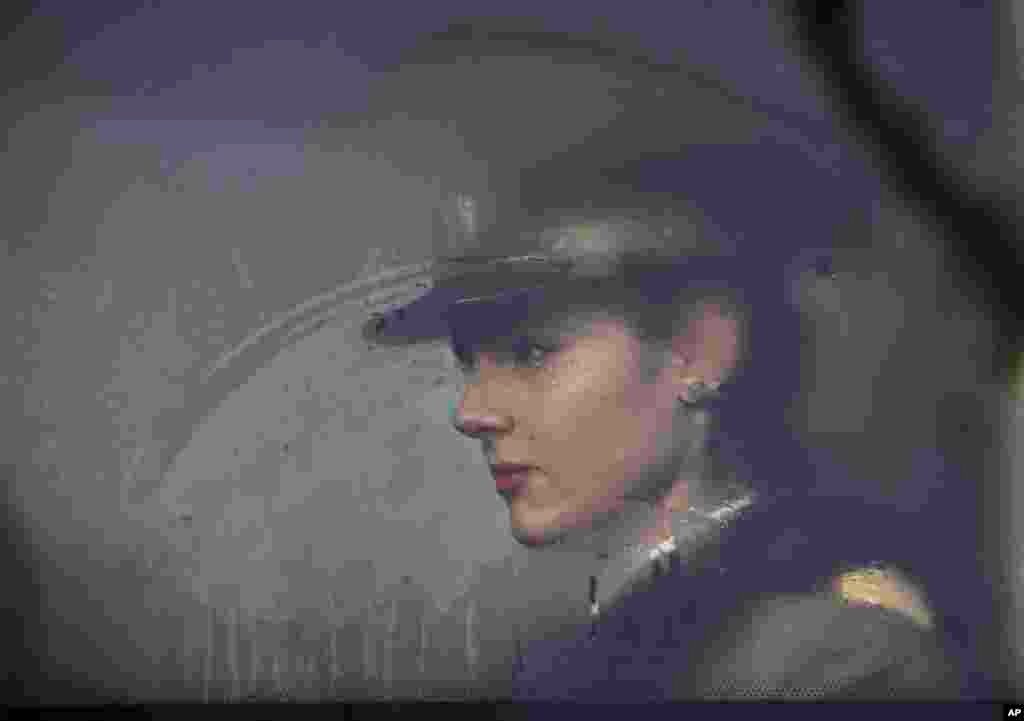 A Romanian military medical student sits on a bus before taking part in Romania&#39;s National Day parade in Bucharest.