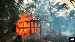 FILE - In this Sept. 7, 2017, photo, houses are on fire in Gawdu Zara village, northern Rakhine state, Myanmar. 