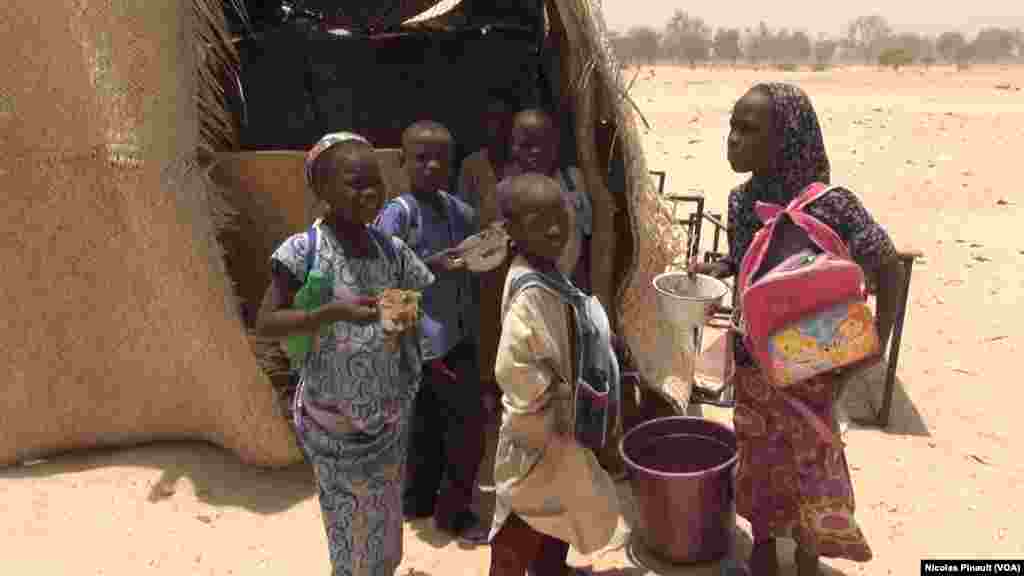 Des enfants avec leurs repas devant l'école à Bosso dans la région de Diffa, Niger, le 19 avril 2017 (VOA/Nicolas Pinault)