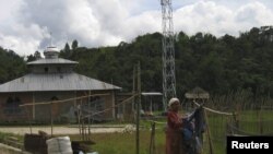 Warga menjemur pakaian dekat stasiun pemancar desa Mambi, Sulawesi Barat. (Reuters/Altobridge)