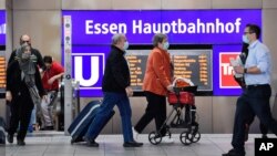 Passengers wear mandatory face masks at the main train station in Essen, Germany, Aug. 24, 2020. 