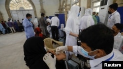 A resident receives a dose of coronavirus disease (COVID-19) vaccine at a vaccination facility in Karachi, Pakistan, Aug. 4, 2021.
