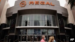 FILE - Two shoppers walk past a Regal movie theater in Irvine, Calif., on Sept. 8, 2020. Warner Bros. said on Oct. 5, 2020 that its sci-fi pic “Dune” will now open in October 2021, instead of this December. 