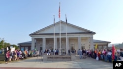 A gathering of same sex marriage supporters, left, and supporters of Rowan County Clerk Kim Davis, right, face off in front of the Rowan County Courthouse in Morehead, Ky., Sept. 1, 2015.