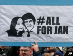 FILE- In this file photo taken on March 16, 2018, people celebrate the resignation of Prime Minister Robert Fico as a way out of the political crisis triggered by the slayings of journalist Jan Kuciak, during a rally in Bratislava, Slovakia.