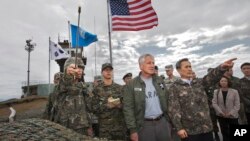 방한 중인 척 헤이글 미국 국방장관(가운데)이 30일 비무장지대를 방문한 가운데, 동행한 김관진 한국 국방장관(가운데 오른쪽)이 북측 지역을 가리키고 있다.