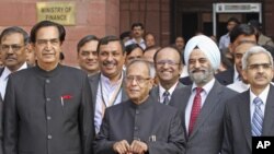 India's Finance Minister Pranab Mukherjee poses as he leaves his office to present the 2012/13 federal budget in New Delhi, March 16, 2012. 