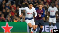 Pemain depan Tottenham Hotspur asal Korea Selatan, Son Heung-min (kiri) berebut bola dengan Arthur, gelandang Barcelona asal Brazil dalam laga penyisihan Grup B antara Barcelona dan Tottenham Hotspur di stadion Camp Nou di Barcelona, 11 Desember 2018.
