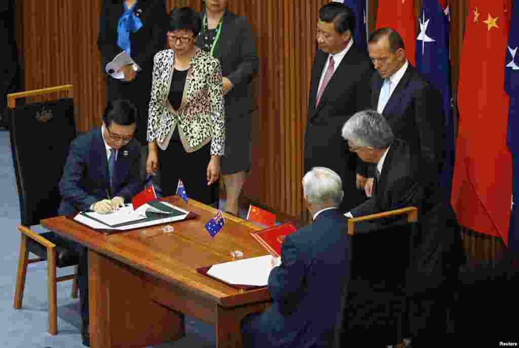 Chinese President Xi Jinping (center) watches the signing ceremony with Australian Prime Minister Tony Abbott for a free trade deal at Parliament House in Canberra, Australia, Nov. 17, 2014.