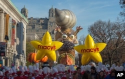 Performers stand in front of balloons at the start of the Macy's Thanksgiving Day Parade, in New York, Nov. 26, 2015.