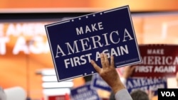 FILE - Delegates hold "Make America First Again" posters on the Republican National Convention floor in Cleveland, Ohio, July 20, 2016. (A. Shaker / VOA)