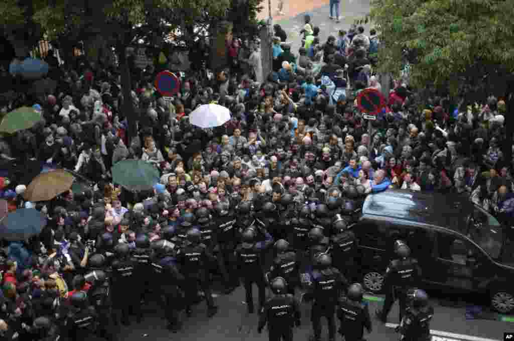 Spanish National Police prevents people from entering a school assigned to be a polling station by the Catalan government in Barcelona, Oct. 1, 2017.