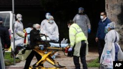 FILE - A patient is evacuated from a nursing home in Riverside, California, April 8, 2020. A similar facilty in Visalia, California, on Thursday reported 154 coronavirus virus cases and 8 deaths.