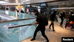 资料照：香港一名抗议者正在打碎九龙一家商场的玻璃围栏。（2019年11月12日）