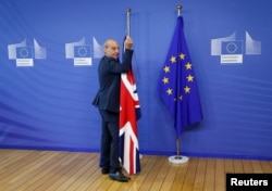 FILE - Flags are arranged at the EU headquarters as Britain and the EU launch Brexit talks in Brussels, June 19, 2017.