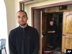 Drew Williams, a member of the Eugene Islamic Center, poses for a portrait outside the building in Eugene, Oregon, as locksmith Jim King upgrades the locks on the front doors, June 1, 2017.