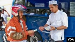 Seorang warga sedang menukarkan uang tunai di layanan Drive Thru Bank Indonesia (foto: VOA).