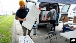 Des Moines Area Religious Council Food Pantry worker Patrick Minor looks over a cooler full of ground pork packages during a pantry stop, Wednesday, May 20, 2020, in Des Moines, Iowa. (AP Photo/Charlie Neibergall) 