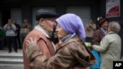 In this 2014 photo, a Ukraine couple attend a public dance. Activities like this may help to keep the brain young -- hers perhaps a little longer than his. (AP Photo/Alexander Zemlianichenko)