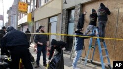 People board up the front of a kosher supermarket thats was the site of a gun battle in Jersey City, N.J., Dec. 11, 2019. 