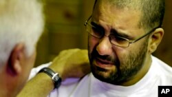 FILE - Prominent Egyptian blogger Alaa Abdel-Fattah, grieves as he receives condolences for his father, Ahmed Seif, at Omar Makram Mosque in Cairo, Egypt, Aug. 30, 2014. 