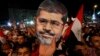 Mohamed Morsi has been ousted as president of Egypt, and his supporters, one holding a Morsi mask, are demanding his reinstatement. 