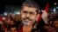 Mohamed Morsi has been ousted as president of Egypt, and his supporters, one holding a Morsi mask, are demanding his reinstatement. 