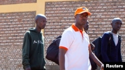 FILE - Rwandan singer Kizito Mihigo is escorted after his release from prison, in Kigali, Rwanda, Sept. 15, 2018.