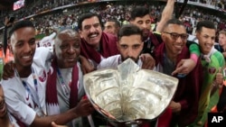 Para pemain dan anggota timnas sepak bola Qatar merayakan kemenangan dalam turnamen sepak bola Piala Asia setelah mengalahkan Jepang pada final di Zayed Sport City, Abu Dhabi, Uni Emirat Arab, 1 Februari 2019.
