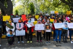 Myanmar refugees hold placards during a demonstration in New Delhi on February 5, 2021, to protest against the military coup in their country. (Photo by Prakash SINGH / AFP)
