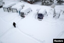 A man walks in the snow ahead of the World Economic Forum (WEF) annual meeting in the Swiss Alps resort of Davos, Switzerland, Jan. 21, 2018