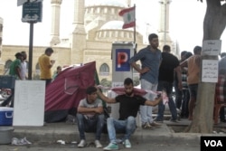 Demonstrators rest near the Ministry of Environment, where protestors have gathered to call for the resignation of Environment minister Mohammad Machnouk, Sept. 16, 2015. (J. Owens/VOA)